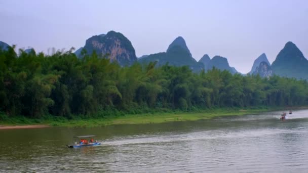 Li Nehri 'ndeki turist teknelerinde arka planda dağları var. — Stok video