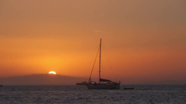 Mikonos, Yunanistan 'da günbatımı ve limanda yatlar