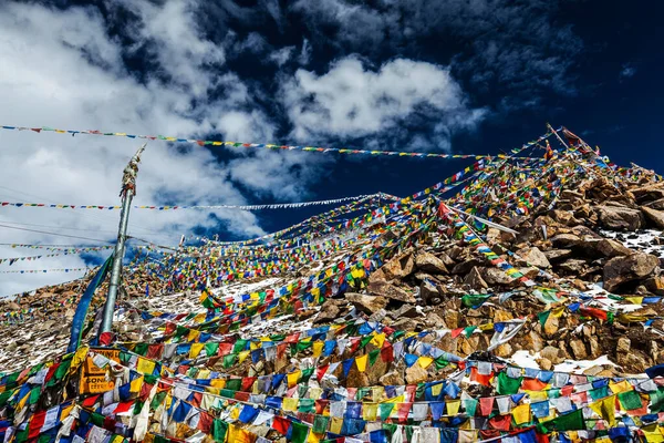 Bandiere di preghiera buddista tibetana sulla cima del passo di Khardung La. Passo automobilabile più alto del mondo 5602 m — Foto Stock