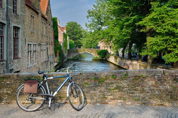 Bicyccle on a bridge near canal and old houses. Bruges Brugge , Belgium — Stok fotoğraf