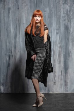 Stüdyoda poz veren güzel kızıl saçlı kadın.