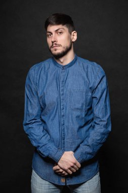 Çekici adam stüdyoda poz veriyor.