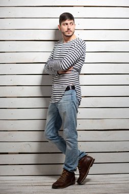 Stüdyoda poz veren esmer bir genç.