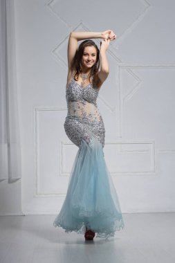 Sevimli genç bir kadın stüdyoda poz veriyor.