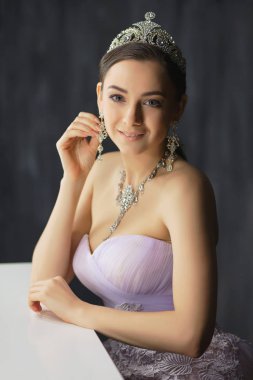 Masanın yanındaki stüdyoda poz veren sevimli bir bayan.