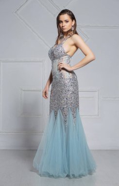 Güzel, genç bir esmer stüdyoda poz veriyor.