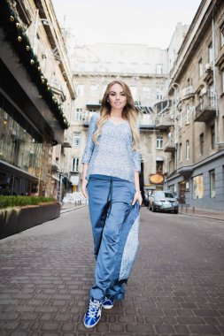 Güzel sarışın dışarıda poz veriyor.