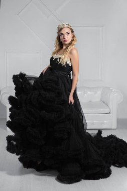 Çekici genç sarışın bir stüdyoda poz veriyor.