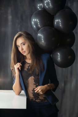 Balonların yanında poz veren çekici genç bayan.