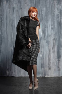 Stüdyoda poz veren güzel kızıl saçlı kadın.