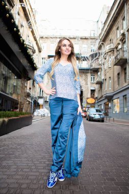 Güzel sarışın dışarıda poz veriyor.