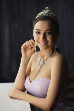 Masanın yanındaki stüdyoda poz veren güzel bir bayan.