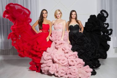 Üç güzel kadın stüdyoda poz veriyor.