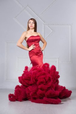 Güzel, genç bir esmer stüdyoda poz veriyor.