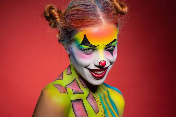 Pretty young lady with a face painting clown — Stock Photo, Image