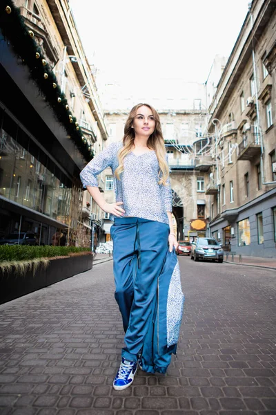 Güzel sarışın dışarıda poz veriyor.