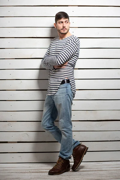 Stüdyoda poz veren esmer bir genç.