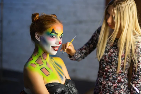 Makyaj sanatçıları güzel bir bayana su makyajı yapar.