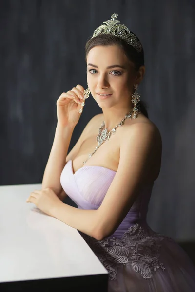 Sexy lady posing in a studio near the table