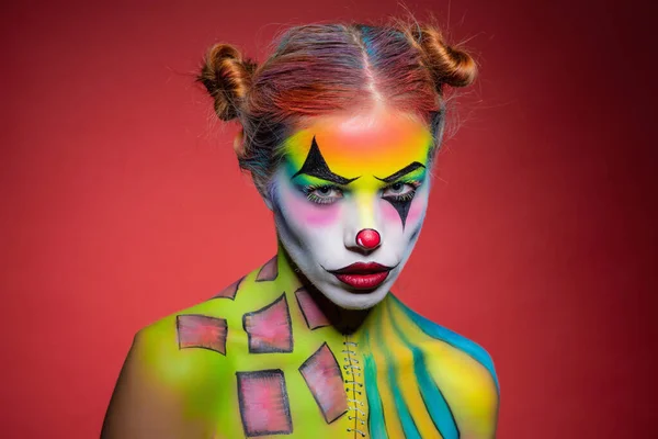 Nice young lady with a face painting clown — 스톡 사진