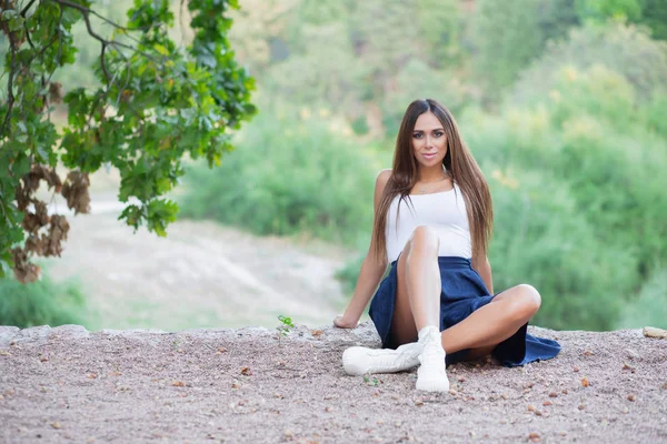 Bonita morena posando sentada em um caminho — Fotografia de Stock