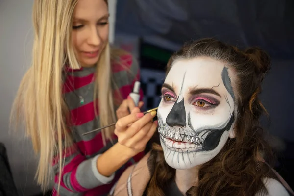 Makijaż artysta stawia malowanie twarzy pięknej kobiety — Zdjęcie stockowe
