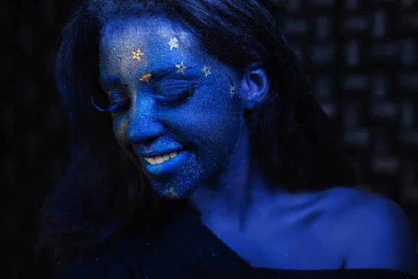 Menina bonita nova com pintura de rosto azul — Fotografia de Stock