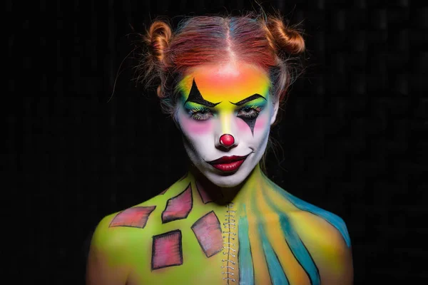 Sexy young woman with a face painting clown — Stock Photo, Image