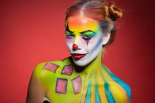 Lovely young lady with a face painting clown — Stock Photo, Image