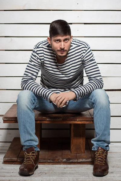 Trevlig man sitter på ett träbord — Stockfoto