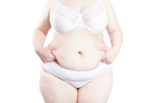 Mujer llena sostiene un pliegue de exceso de grasa en el estómago (sobrepeso —  Fotos de Stock