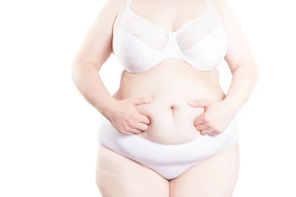 Mujer llena sostiene un pliegue de exceso de grasa en el estómago (sobrepeso — Foto de Stock