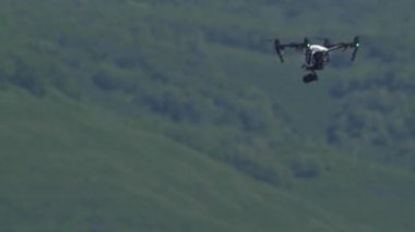Beyaz drone ile dijital fotoğraf makinesi üzerinde kahverengi ayı gökte uçan