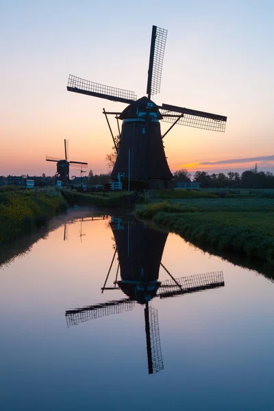 Salida del sol con molinos de viento tradicionales holandeses reflejados en la calma w —  Fotos de Stock