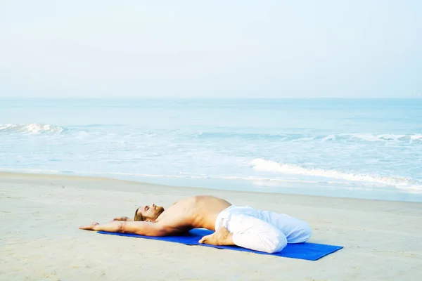 Mat 'in atletik adamı plajda yoga yapıyor. — Stok fotoğraf