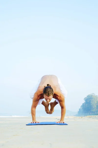 Mat 'in atletik adamı plajda yoga yapıyor. — Stok fotoğraf