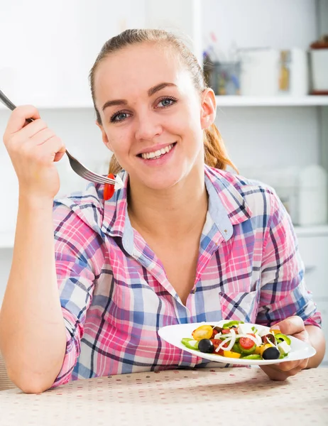 Retrato de mujer joven comiendo ensalada en la cocina —  Fotos de Stock