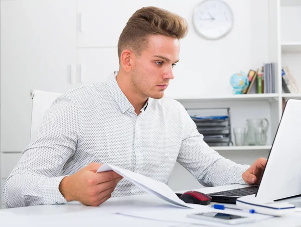 Young man with laptop in office — Stock Photo, Image