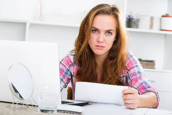 Mädchen in Schwierigkeiten mit Laptop am Tisch — Stockfoto