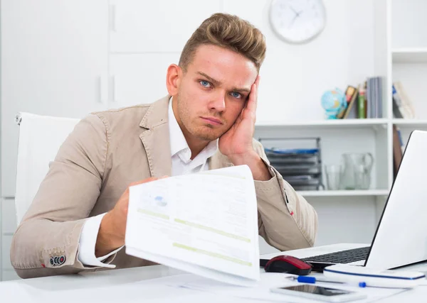 Стрессовый бизнесмен с документами в офисе — стоковое фото