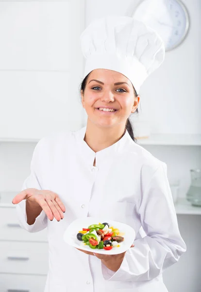 Vrouw kok holding plaat van salade — Stockfoto