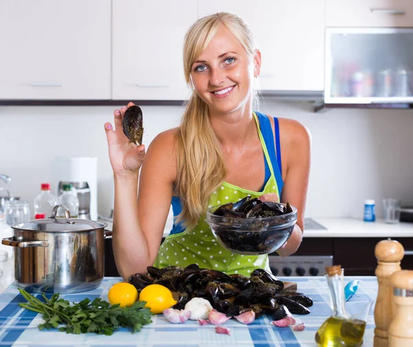 Blondine posiert mit frischen Muscheln in Küche — Stockfoto