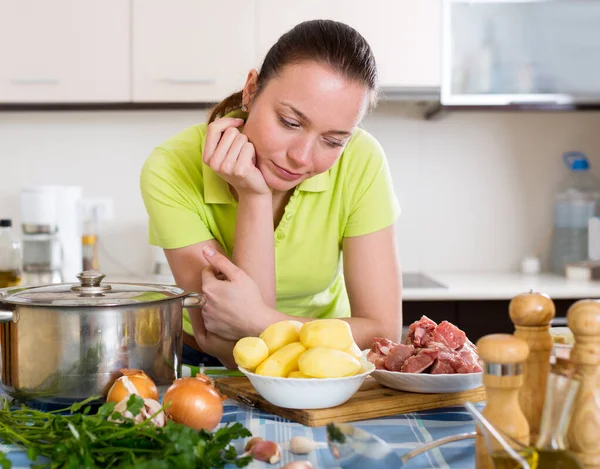 Femme perplexe avec de la viande — Photo