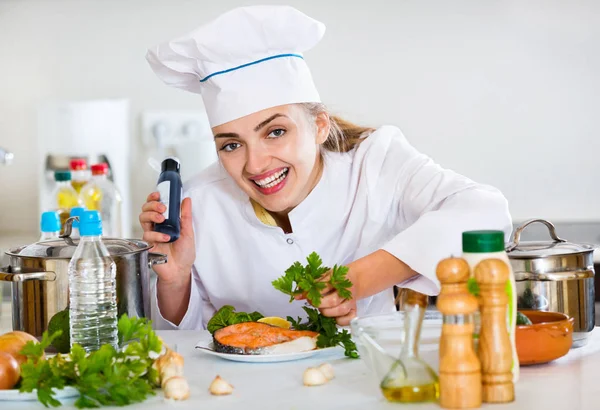 Professionele lachende chef-kok decoreren schotel met zalm — Stockfoto