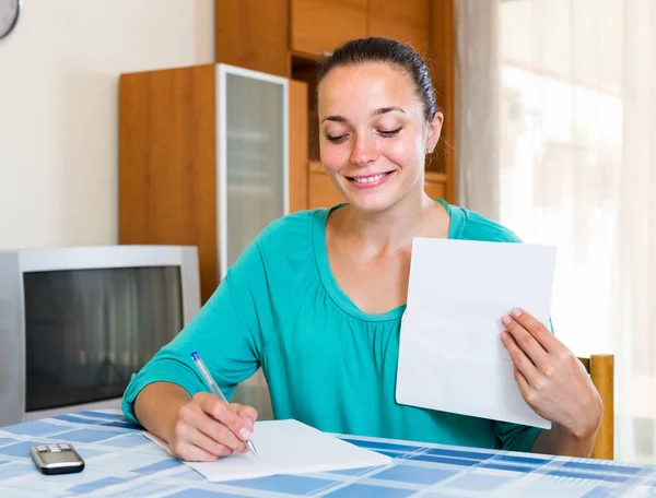 Pige, der arbejder med dokumenter derhjemme - Stock-foto