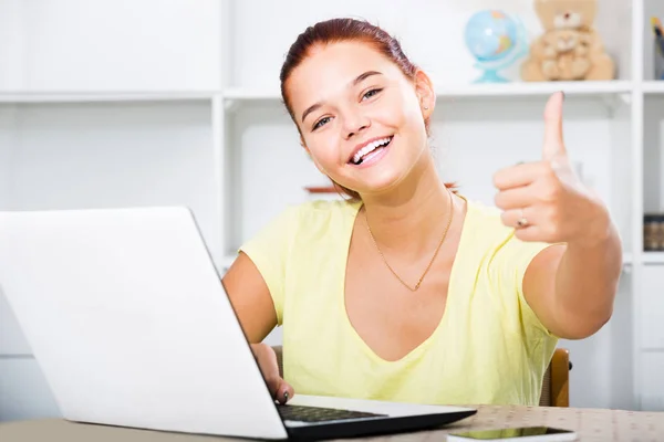 Meisje school leerling zitten met laptop en tonen duimen omhoog — Stockfoto