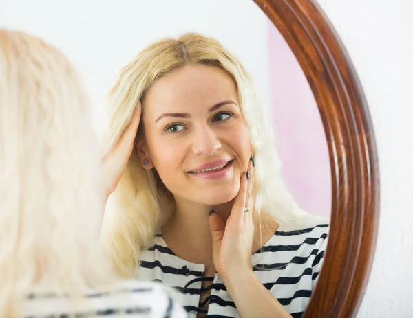 Mignonne fille regarder elle-même dans miroir à l'intérieur — Photo