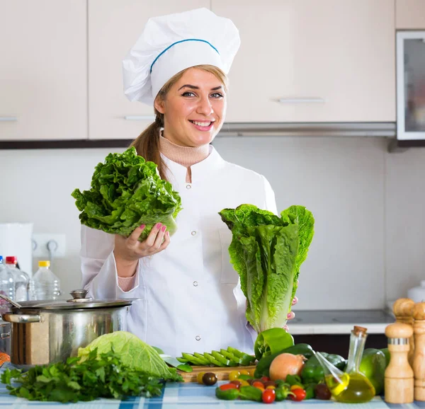 Joven chef con lechuga fresca posando en la cocina —  Fotos de Stock