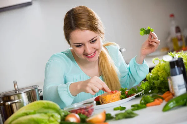 Femme au foyer positive avec assiette de salade dans la cuisine — Photo