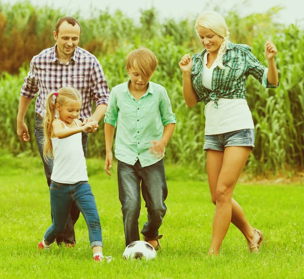 Familia jugando fútbol en el campo — Foto de Stock